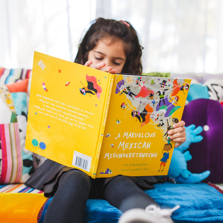girl holding picture book about mexico